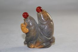 A Chinese chalcedony twin fish snuff bottle, carved as two leaping carp, with a Lingzhi fungus
