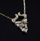 An 18ct gold and diamond set pendant necklace, the stylised mask shaped pendant set with round