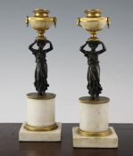 A pair of Regency bronze, ormolu and white marble candlesticks, modelled with classical women