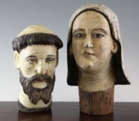 A Spanish colonial carved and painted bust of a saint, with glass eyes and a similar painted