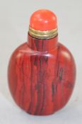 A Chinese bloodstone snuff bottle, 6.5cm., coral stopper