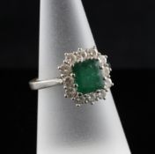 An 18ct white gold, emerald and diamond cluster ring, size N.
