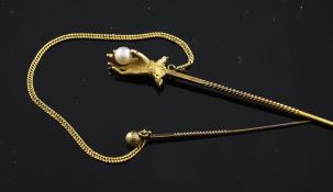 An early 20th century gold stock pin, modelled as a hand holding a cultured pearl attached to a