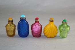 Five Chinese coloured glass snuff bottles, largest 6.4cm.