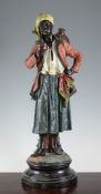 A large Austrian cold painted terracotta figure of an Arab street seller, standing on a circular