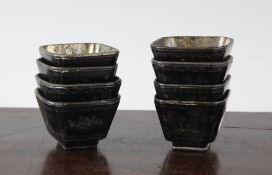 Eight lac burgaute shaped square cups, Kangxi period, each decorated with figures in landscapes,