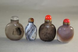Four Chinese agate snuff bottles, one with black moss like inclusions, one float on water, third