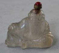 A Chinese rock crystal figural scent bottle, carved as a recumbent bearded man, 6cm.