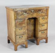 A Queen Anne walnut kneehole desk, with top secretaire drawer and an arrangement of drawers and a
