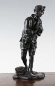 A Japanese bronze figure of a farmer, Meiji period, standing leaning upon his hoe and holding a pipe