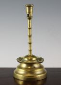 A Flemish brass candlestick, c.1500, with slender knot stem and broad base, 10.5in.