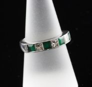 A modern platinum, diamond and emerald half eternity ring, set with four emeralds and three princess