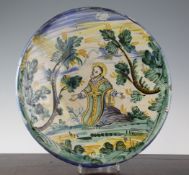 An Italian maiolica dish, probably Montelupo, 17th century, painted with a kneeling saint amid trees