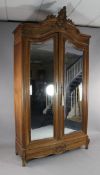 A French Louis XV design carved walnut armoire, with two mirrored doors, W.4ft 5in. H.9ft 3in.