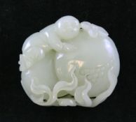 A Chinese pale celadon jade carving of a boy on giant pomegranates, 18th / 19th century, with