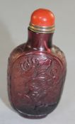 A Chinese amethyst glass snuff bottle, carved in relief to each side with figures in a boat, and