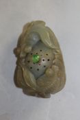A Chinese green jade snuff bottle, carved as two ornamental fish circling a lotus pod, the stone
