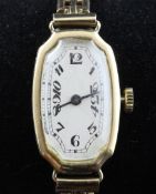 A lady`s 1920`s 9ct gold wrist watch in Rolex case, the shaped oval dial with tumbling Arabic