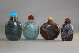 Four Chinese jasper snuff bottles, of varying colours and inclusions, largest 6.5cm., stoppers