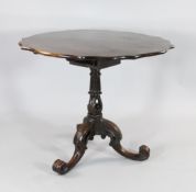 A George III Irish mahogany tripod table, the scalloped shaped top on birdcage movement, the