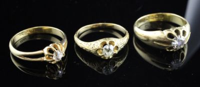 Three gentleman`s early 20th century gold claw set solitaire diamond rings, two stamped 18ct, one