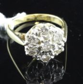 An 18ct gold and seven stone diamond set flower head cluster ring, size L.