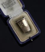 A cased early 20th century gold thimble, with chased foliate panels, unmarked, 0.75in.