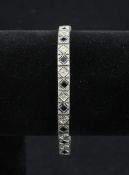 An 18ct white gold, sapphire and diamond line bracelet, set with square cut stones, approx. 7in.
