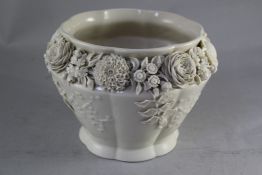 A Belleek jardiniere, 2nd period, late 19th century moulded with prunus, the shoulder profusely