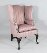 A George II design carved and stained wood wingback armchair, with striped upholstery, on cabriole