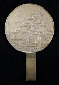 A Japanese bronze hand mirror, Meiji period, cast in relief with cranes amid pine and a minogame