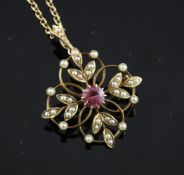 An Edwardian 15ct gold, pink tourmaline and split pearl set pendant/brooch, of foliate design, on