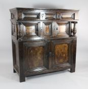 A Jacobean style oak court cupboard, with marquetry inlaid cupboard doors and carved vase shaped