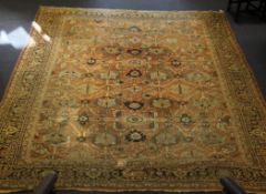 A large 19th century Turkish carpet, with field of geometric floral motifs, on a pale orange ground,