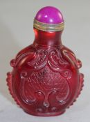 A Chinese ruby glass snuff bottle, of flask form, moulded and carved in relief with chi-dragons