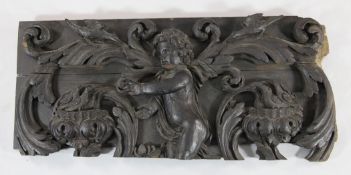 A 17th century North European carved oak panel, with a central cherub, acanthus scrolls and