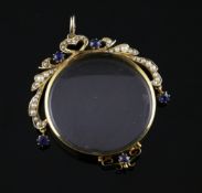 A Victorian 15ct gold, sapphire and split pearl pendant locket, of circular form, with scroll