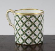 A Sevres style small mug, decorated with a diaper design of green leaves around gilt and puce