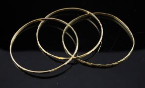A set of three middle eastern gold bangles, with cut decoration, unmarked, 28.3 grams.