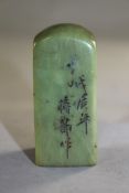 Two Chinese green soapstone seals, carved in relief with a scholar beneath a prunus tree, rockwork