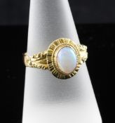 An Edwardian 18ct gold and white opal oval dress ring, with carved shank and milled setting, size