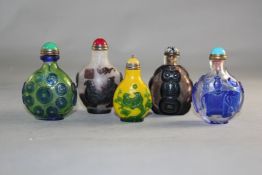 Five Chinese overlaid glass snuff bottles, with various designs including an elephant, sages, birds,