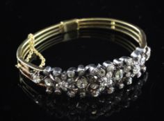 A Victorian gold, silver and diamond cluster stiff bracelet, set with forty eight stones of