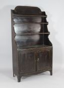 A Regency simulated rosewood waterfall bookcase, with two cupboard doors, on bracket feet, W.2ft