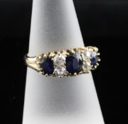 An 18ct gold seven stone sapphire and diamond half hoop ring, size N.