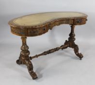 A Victorian carved walnut kidney shaped writing table, with cream and gilt tooled skiver, carved