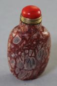 A Chinese jasper snuff bottle, the stone with pebble like inclusions in red, grey and beige, 6.5cm.,