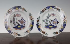 A pair of English delft polychrome plates, each painted with flowers and rockwork in Chinese