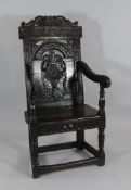 A 17th century joined oak Wainscot chair, with carved panel back initialled R.T., and a carved