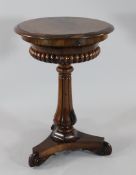 An early Victorian circular rosewood teapoy, with fitted interior, on gadrooned vase column and